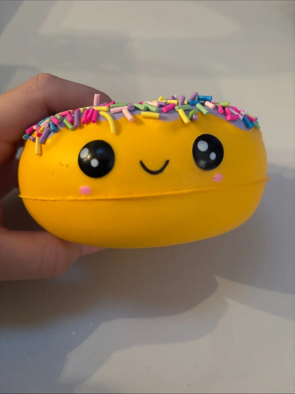 Smiling Yellow Donut Plush Toy with Purple Frosting and Rainbow Sprinkles